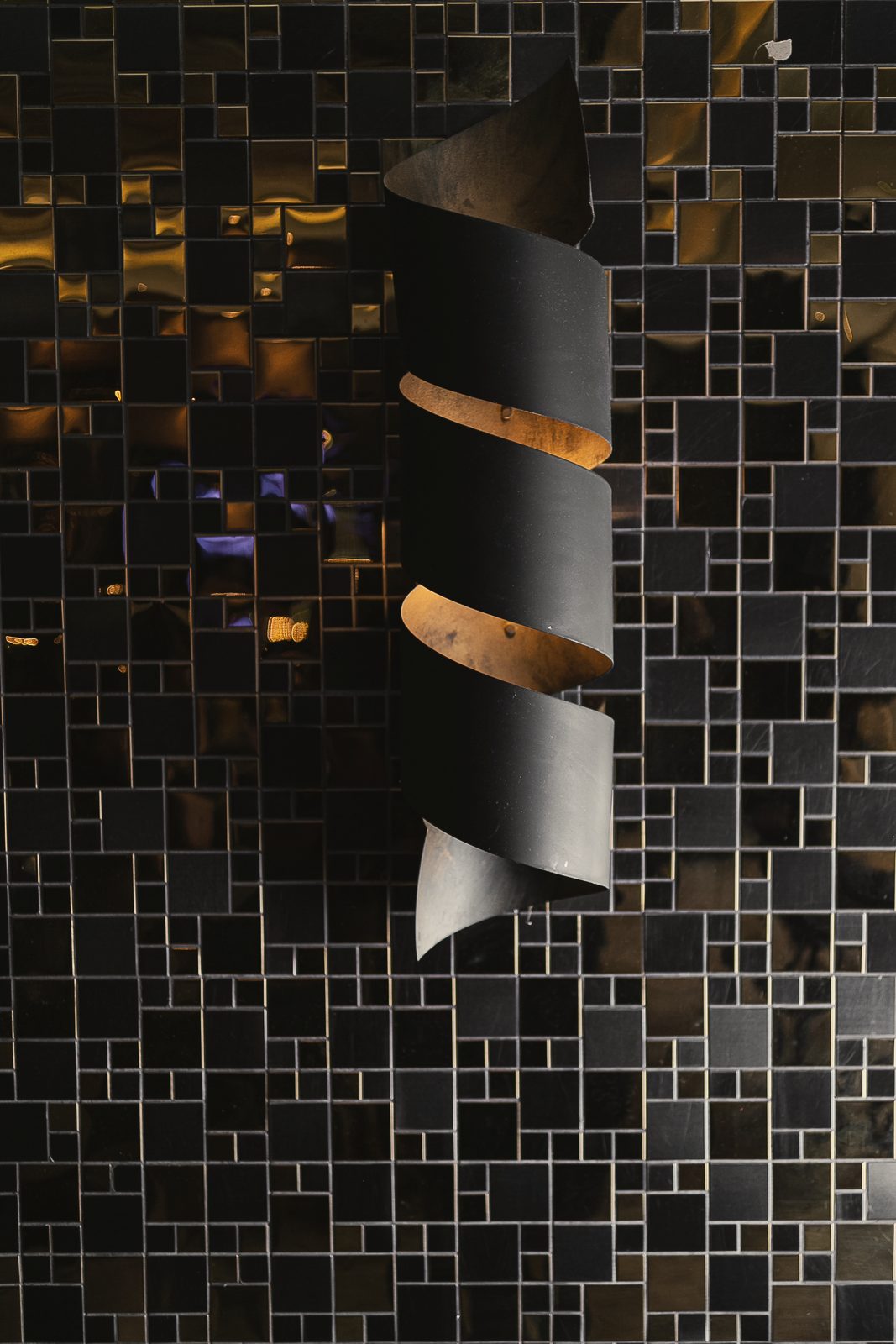 Parede de mosaico escuro com peça de metal